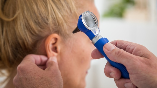 Arzt untersucht das Ohr einer Patientin | Bild: picture-alliance/dpa/Christin Klose