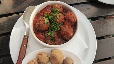 Papas arrugadas (runzelige Kartoffeln in Salzwasser gekocht) in einer roten Soße | Bild: Annette Eckl