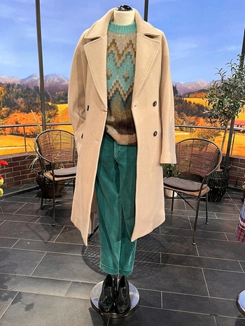 Outfit für die Damen: Pullover in einem Grün, das ins Mint geht. Dazu eine Cordhose. Einen hellen Mantel. Die Schuhe sind Vintage Loafer, die mit Fransen daherkommen. | Bild: Wir in Bayern