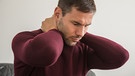 Mann hält verspannten Nacken | Bild: picture-alliance/dpa/Kristin Klose