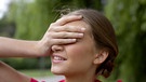 Junge Frau hält sich die Hand vor die Augen. | Bild: picture alliance
