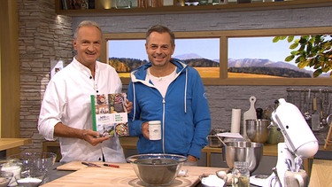 Schmankerlkoch Andreas Geitl mit dem Wir-in-Bayern-Kochbuch und Moderator Michael Sporer | Bild: BR