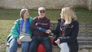 Reporterin Steffi Heiß im Interview mit einem Paar auf einer Parkbank | Bild: BR