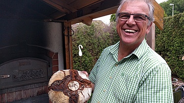 Klaus Herter mit einem Laib selbstgebackenem Brot | Bild: BR