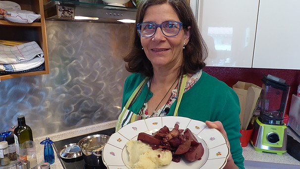 Marion Reinhardt mit einem Teller geschmortem Wurzelgemüse und Pastinaken-Püree | Bild: BR