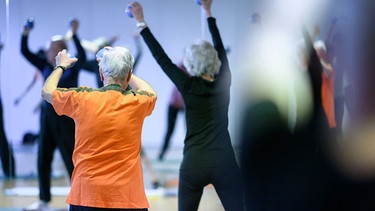 alles wissen | Magazin - Körper - Teilnehmerinnen und Teilnehmer machen während einer Sportstunde für Menschen ab 60 eine Übung mit leichten Gewichten. | Bild: picture alliance/dpa | Sebastian Gollnow