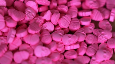 Ecstasy-Tabletten in Form von Totenköpfen liegen im Zollamt auf dem Tisch.  | Bild: dpa-Bildfunk/Oliver Berg