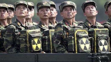 Nordkoreanische Soldaten tragen Gepäck mit Atomsymbol | Bild: picture-alliance/dpa