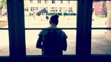 Studentein sitzt vor einem Fenster | Bild: BR