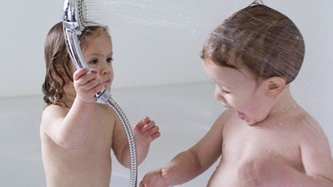 Kleinkinder in der Badewanne, spritzen sich gegenseitig mit Wasser an.  | Bild: picture-alliance/dpa