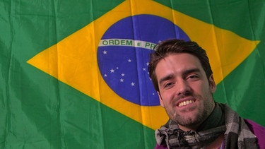 Student Lucas aus Sao Paulo vor der Brasilienflagge. Er wohnt im Roncalli-Kolleg.  | Bild: BR