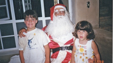 Lucas mit seiner Schwester Marina auf dem schoß vom Papai Noel | Bild: BR