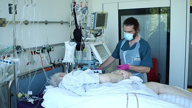 Marc Schlinger, angehender Mediziner, ohne Abitur aber mit einer Ausbiludng im Pflegebruf am Krankenbett einer Patientin | Bild: BR