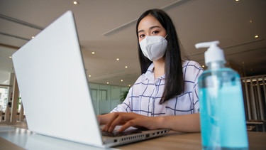 Studentin ausgestattet mit FFP2 Maske und großer Desinfektionsflasche (Symbol für Risikogruppe der Studierenden) | Bild: colourbox.com