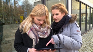 Milena und Hannah checken auf ihrem Pad, welche Uni mehr Semianre bietet. | Bild: BR