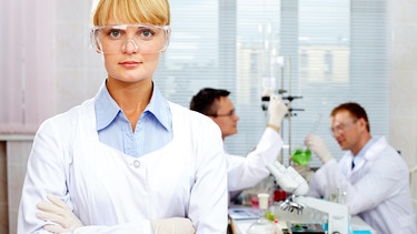 Wissenschaftlerin im Labor mit Kollegen im Hintergrund | Bild: colourbox.com