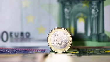 Eine Ein-Euro-Münze vor einem Hundert-Euro-Geldschein | Bild: BR/Lisa Hinder