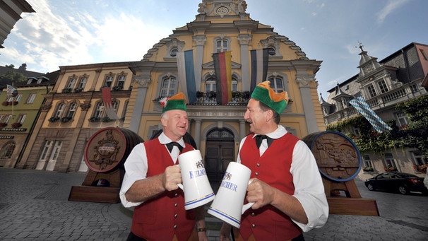 Büttner prosten sich vor aufgestellten Prunkfässern am Rathaus in Kulmbach (Oberfranken) zu. | Bild: picture-alliance/dpa