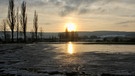 Sonnenuntergang in Trommetsheim. Das Hochwasser ist teilweise angefroren und die Sonne spiegelt sich wunderschön darin. | Bild: Ursula Knoll, Trommetsheim, 08.12.2023