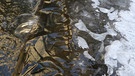 "Gold und Silber". Nur ein kleines Loch hat das Eis freigelassen für den kleinen Wasserfall in einem Bach. Durch die abendliche Sonneneinstrahlung ergibt sich die goldene Farbe. | Bild: Peter Sunkel, Roth, 15.01.2024
