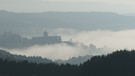 Dichter Nebel liegt über Kronach, die Festung schaut nur als Silhouette heraus. | Bild: Sigrid Arneth
