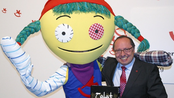 Messechef der Spielwarenmesse Nürnberg, Ernst Kick, zusammen mit dem Messe-Maskottchen Teena  | Bild: picture-alliance/dpa