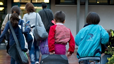 Asylbewerber tragen Taschen in ein Haus | Bild: picture-alliance/dpa