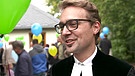Pfarrer Daniel Lunk der lebendigen Dorfgemeinschaft Hallerstein im Fichtelgebirge auf einem Fest mit Luftballon in der Hand. | Bild: Bayerischer Rundfunk