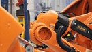 ARCHIV - Ein Arbeiter kontrolliert in Augsburg einen Roboter von Kuka. | Bild: picture-alliance/dpa/Stefan Puchner