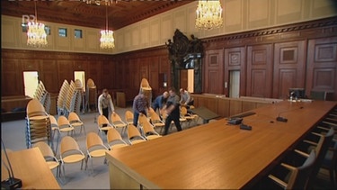 Arbeiter stellen Stühle im Saal 600 auf | Bild: Bayerischer Rundfunk