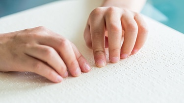 Blindes Kind ertastet mit den Händen die Brailleschrift | Bild: picture-alliance/dpa