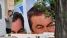 Arbeiter entfernen Wahlplakate mit dem Bild von Markus Söder (CSU), Ministerpräsident von Bayern, von einer Litfaßsäule.  | Bild: dpa-Bildfunk/Peter Kneffel
