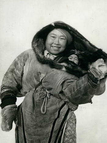 Ein Foto aus dem Jahr 1950 zeigt wie eine Eskimomutter traditionell ihr Baby trägt: Das Kind wird ganz eng am Körper getragen und ist mit einer Kordel um die Hüften gesichert. | Bild: picture alliance / ZUMAPRESS.com | Keystone Pictures USA