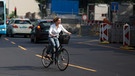 Verkehrsregeln für Fahrradfahrer: Frau auf dem Fahrrad gibt ein deutliches Handzeichen beim Linksabbiegen. | Bild: picture-alliance/dpa