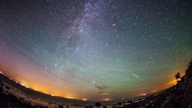 Am klaren Nachthimmel ist das Band der Milchstraße - und eine Sternschnuppe - zu sehen. Aufgenommen am 13.08.2015 auf Fehmarn in Schleswig-Holstein. | Bild: dpa-Bildfunk/Daniel Reinhardt