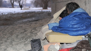 Auf der Straße zu leben ist bei Schnee und Kälte besonders hart. Dieser Obdachlose hat sein Lager unter der Wittelsbacherbrücke in München aufgeschlagen. | Bild: picture-alliance/dpa