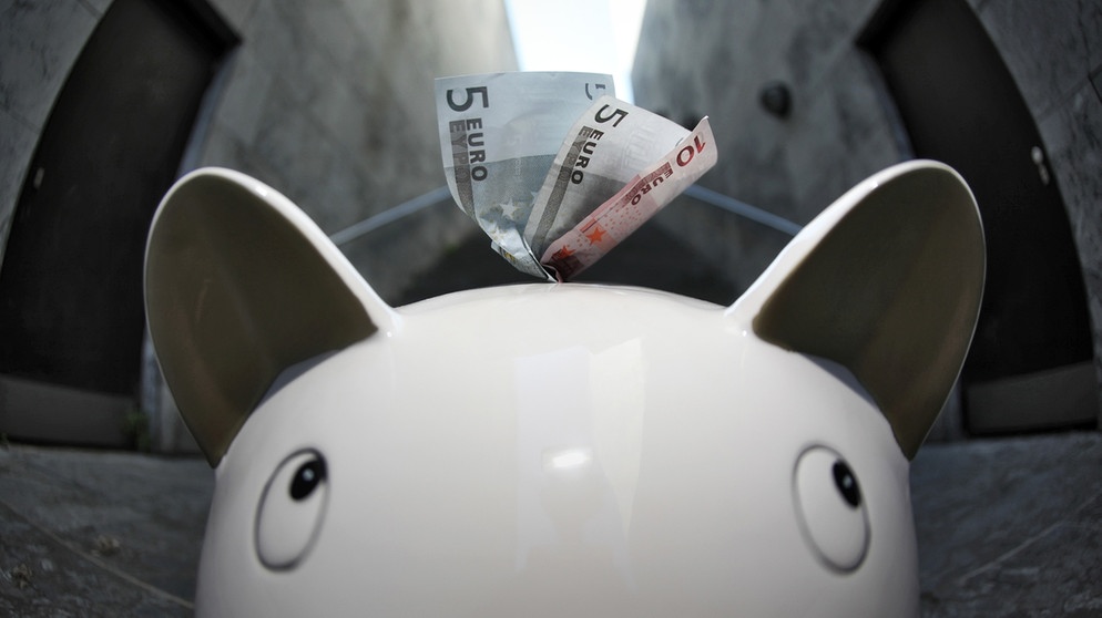 Nahaufnahme von einem Sparschwein mit Euro-Scheinen im Schlitz | Bild: picture-alliance/dpa