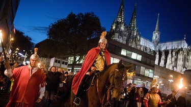 Der "Heilige Sankt Martin" reitet bei einem Martinszug am Dom von Köln vorbei.  | Bild: dpa-Bildfunk/Rolf Vennenbernd