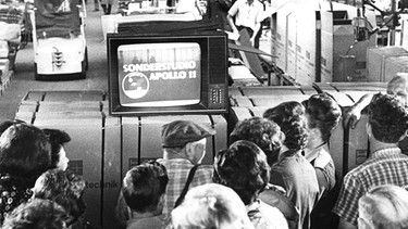 Archiv: Beschäftigte der Firma Haas + Sohn verfolgen die Sonderberichterstattung über den Raumflug von Apollo 11 und der Landung der ersten Menschen auf dem Mond. Die Mondlandung war auch als Medienereignis eine große Nummer. Manche blieben dafür die ganze Nacht wach. Auch die Sender waren im Ausnahmezustand.  | Bild: dpa-Bildfunk/Roland Witschel