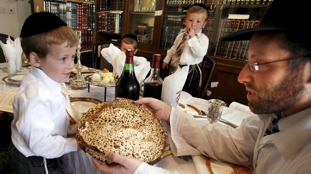 Eine ultraorthodoxe jüdische Familie feiert in der Siedlung Betar Illit im Westjordanland Seder, das Pessach-Abendessen (Aufnahme vom 2. April 2007). Das ungesäuerte Brot Mazza wird herumgereicht.  | Bild: picture alliance / dpa | epa Nati Shohat-Flash90