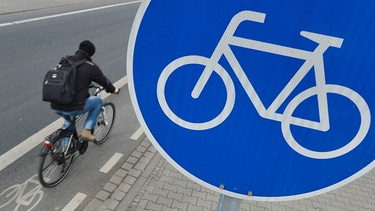 Ein Mann fährt mit seinem Fahrrad auf einem mit einem Verkehrsschild gekennzeichneten Radweg. | Bild: dpa-Bildfunk/Arne Dedert