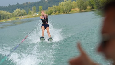 Eine Frau beim Wasserskifahren an einem See. | Bild: colourbox.com
