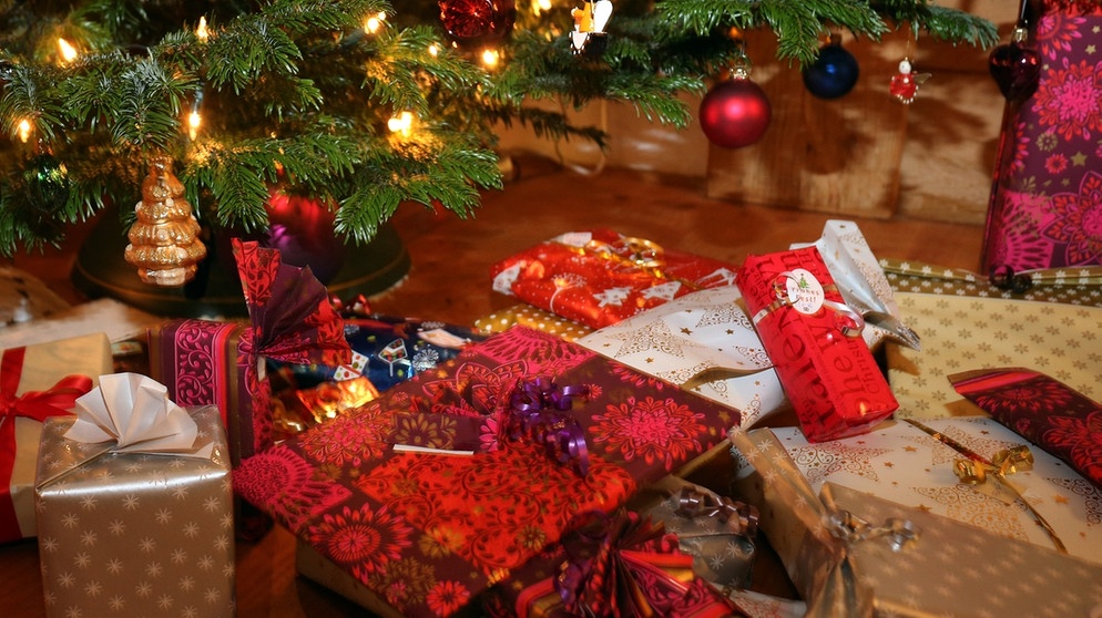Verpackte Weihnachtsgeschenke liegen unter einem Christbaum.  | Bild: dpa-Bildfunk/Karl-Josef Hildenbrand
