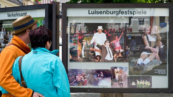 Ein Paar schaut sich am 08.06.2012 in Wunsiedel (Oberfranken) einen Aushang zu den Luisenburgfestspielen an. | Bild: picture-alliance/dpa