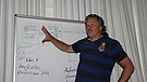 Ein Trainer erklärt vor einem Schaubild, wie man eine Schul-Homepage aufbauen könnte. | Bild: BR