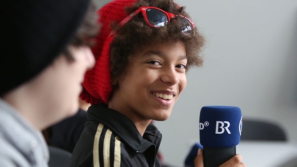 Junge hält ein BR-Mikrofon. | Bild: BR Medienkompetenz