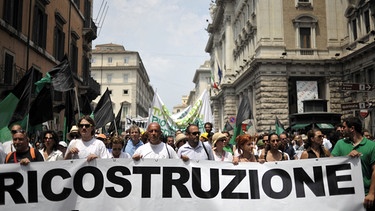 Demonstranten fordern den Wiederaufbau von L'Aquila  | Bild: picture-alliance/dpa| Guido Montani