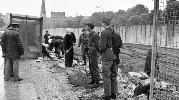 [03.07.1980] Ostberliner Bauarbeiter haben unter Aufsicht der Volkspolizei am 29.05.1980 damit begonnen die alte Mauer in der Bernauer Straße in Berlin abzureissen und mit einem Drahtzaun zu ersetzen. | Bild: picture-alliance/dpa