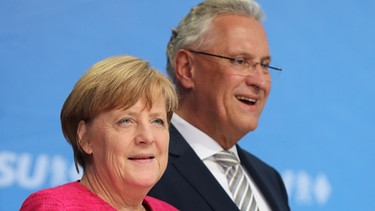 CSU-Spitzenkandidat Joachim Herrmann und Bundeskanzlerin Angela Merkel (CDU). | Bild: picture-alliance/dpa/Sammy Minkoff
