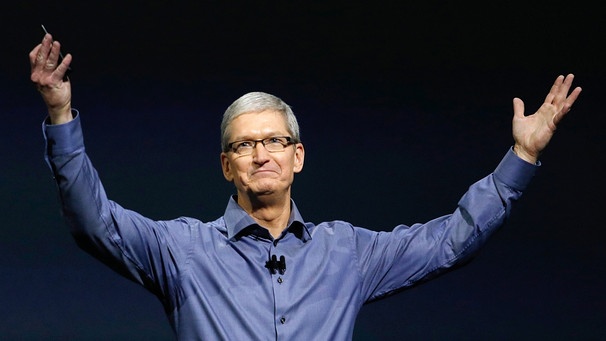 Apple-Boss Tim Cook hält bei einer Veranstaltung 2015 ein iPhone in der Hand (Archivbild) | Bild: picture-alliance/dpa